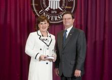 Deputy State Veterinarian and Public Health Veterinarian Dr. Brigid Elchos, left, accepts her alumnus of the year award from Dr. Kent Hoblet, dean of Mississippi State University College of Veterinary Medicine. Elchos received the honor because of her outstanding achievements and leadership. (Photo by MSU University Relations/Megan Bean)