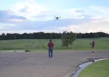 David Young, left, and Sean Meacham, both with the Mississippi State University Geosystems Research Institute, demonstrate one model of unmanned aircraft in Raymond on Aug. 29 for members of Mississippi’s U.S. congressional staff during a two-day tour of the state’s agricultural industry. (Photo by MSU Extension Service/Susan Collins-Smith)