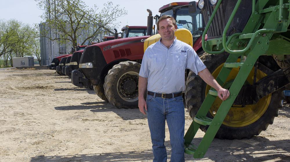 Will Smythe, Thad Cochran Agricultural Leadership Program, Class of 2019 A man wearing a blue collared shirt rests his hand on a green tractor with several red tractors parked behind him.