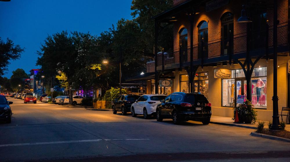 Downtown lights shining along the sidewalk.