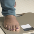 A close up picture of a person's foot stepping on a scale. 