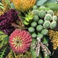 A flower arrangement with various types of flowers and greenery is displayed.