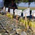 Glass jars filled with produce are lined up with price tags.