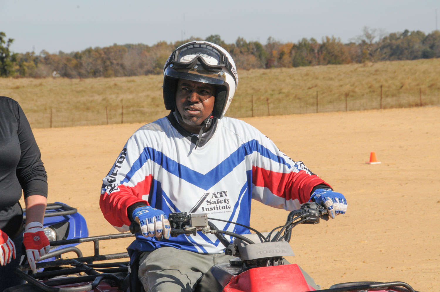 A man wearing a helmet and riding an ATV.