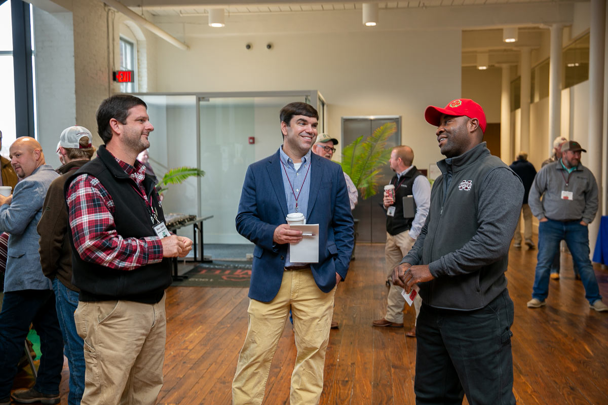 Three men talking to each other.