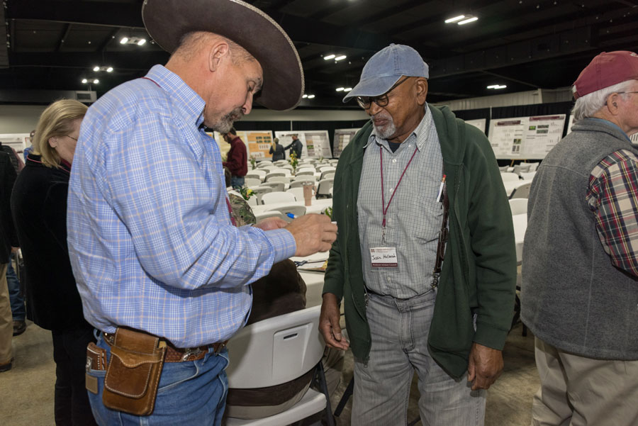 A Black man talks with a white man.