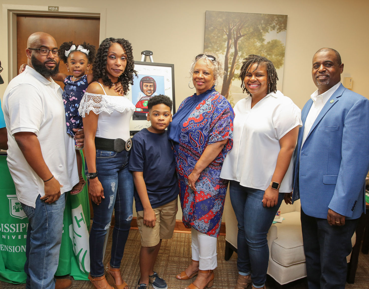 Seven family members standing in a row, smiling.