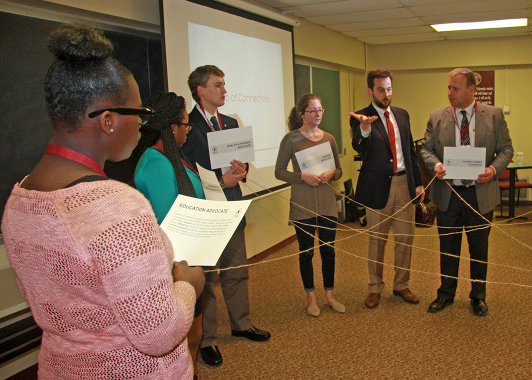 group of participants in a circle connected by string.