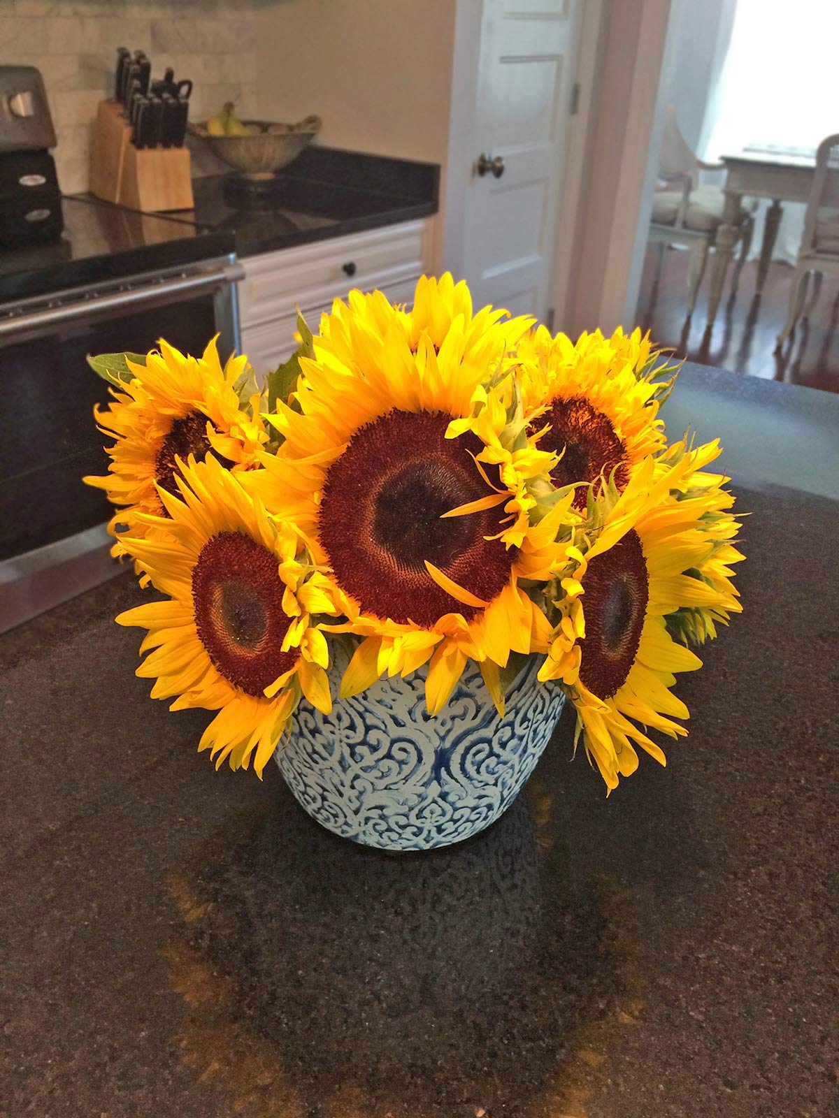 A vase of sunflowers on a kitchen table.