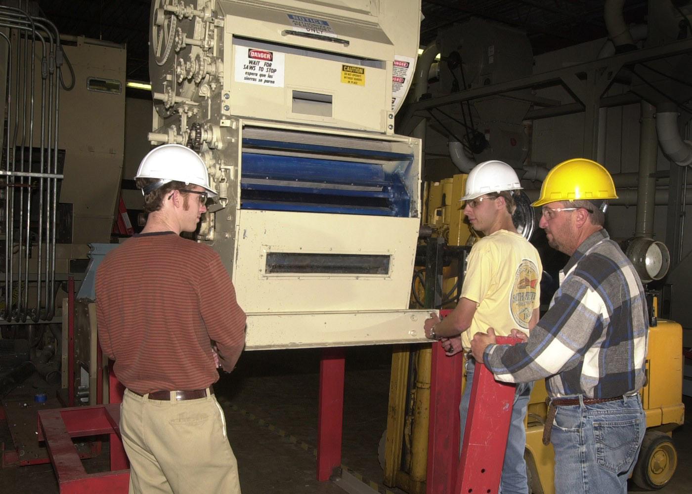 Gin management technology students Casey Newsom, left, of Rolling Fork and Tyler Branch of Greenwood assist MSU engineering technician David Trammell with upgrades to the university's mini-gin. The gin equipment provides students with hands-on experience in cotton ginning.