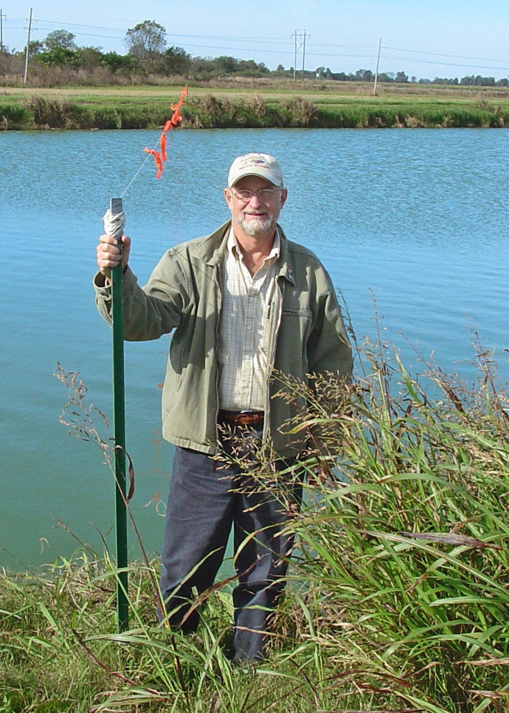 Cormorants and pelicans need about 100 yards of open water to take off and land. Jim Steeby, Extension aquaculture specialist with Mississippi State University, shows strings such as these placed across a pond about 60 yards apart that limit the open water available to the birds.