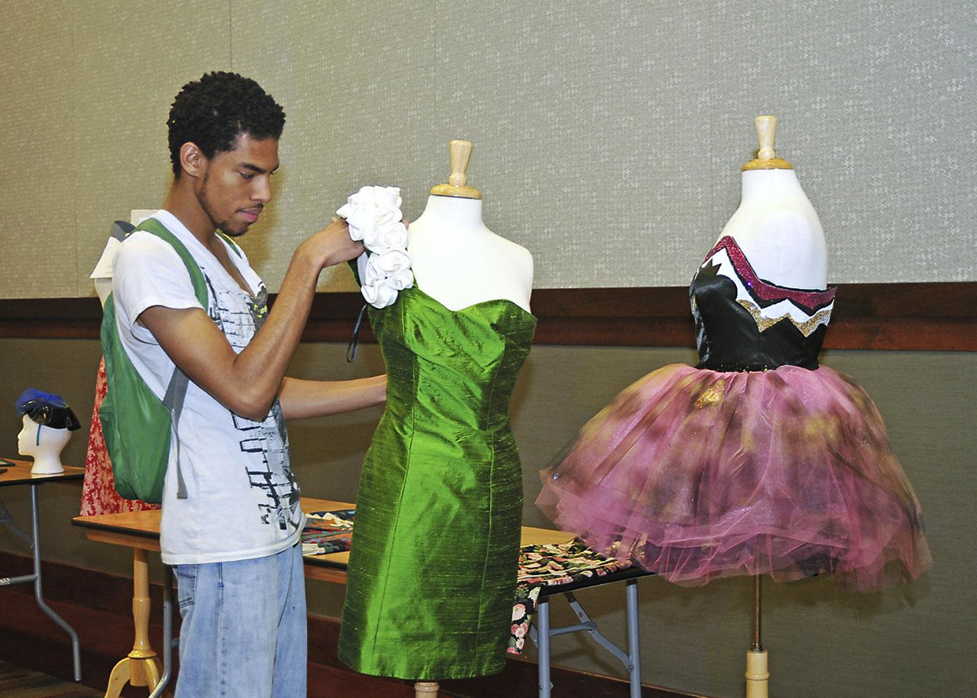 MSU freshman Jay Grishby of Jackson puts the finishing touches on his haute couture cocktail dress that was featured in a recent campus fashion exhibit.