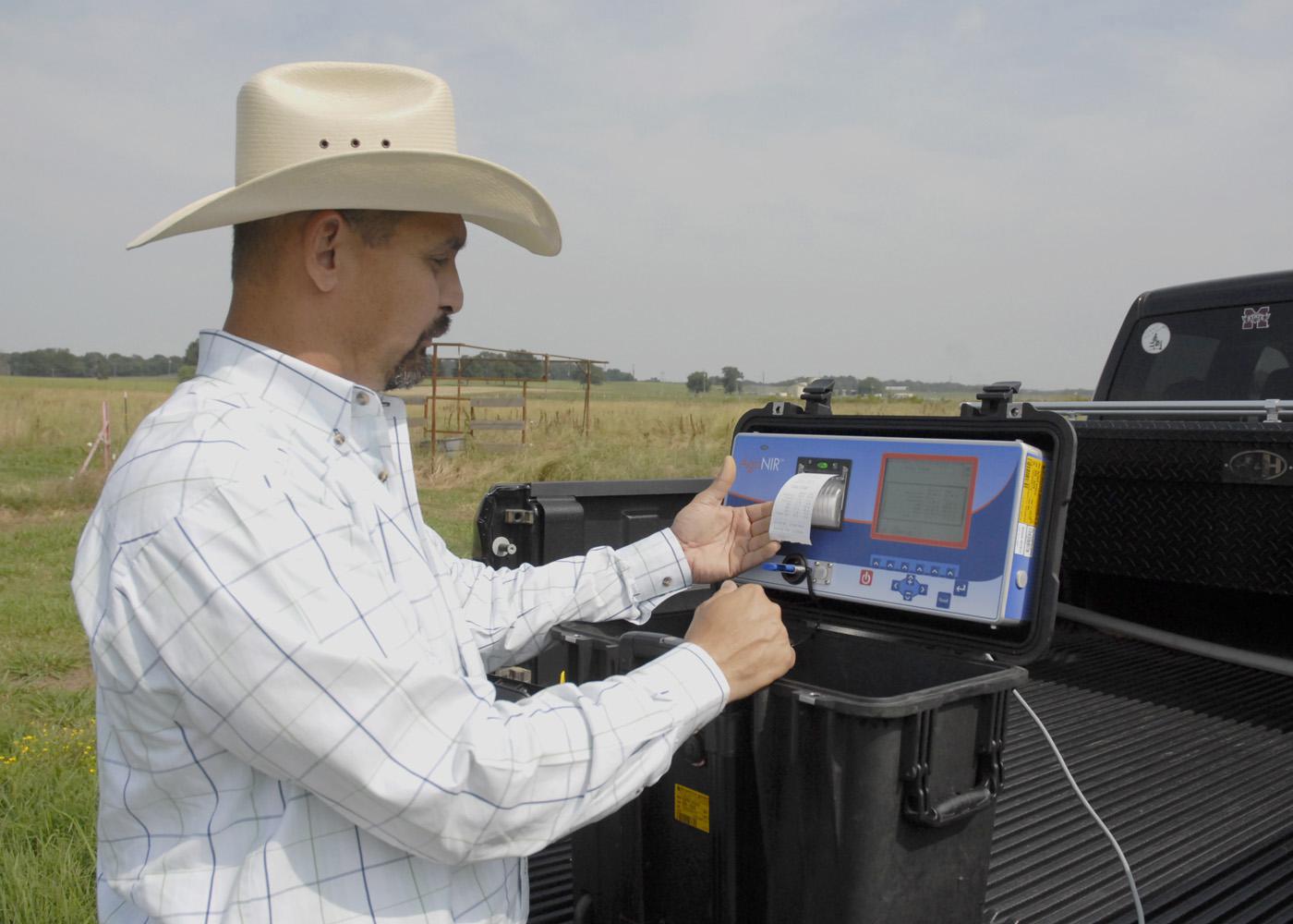 Mississippi State University Extension Service forage specialist Rocky Lemus examines a bermudagrass analysis from a portable forage tester on May 21, 2012, at the Henry H. Leveck Animal Research Farm, the forage unit at MSU's South Farm in Starkville. Forage and cattle producers can use test results to make harvest and feed supplement decisions. (Photo by MSU Ag Communications/Linda Breazeale)