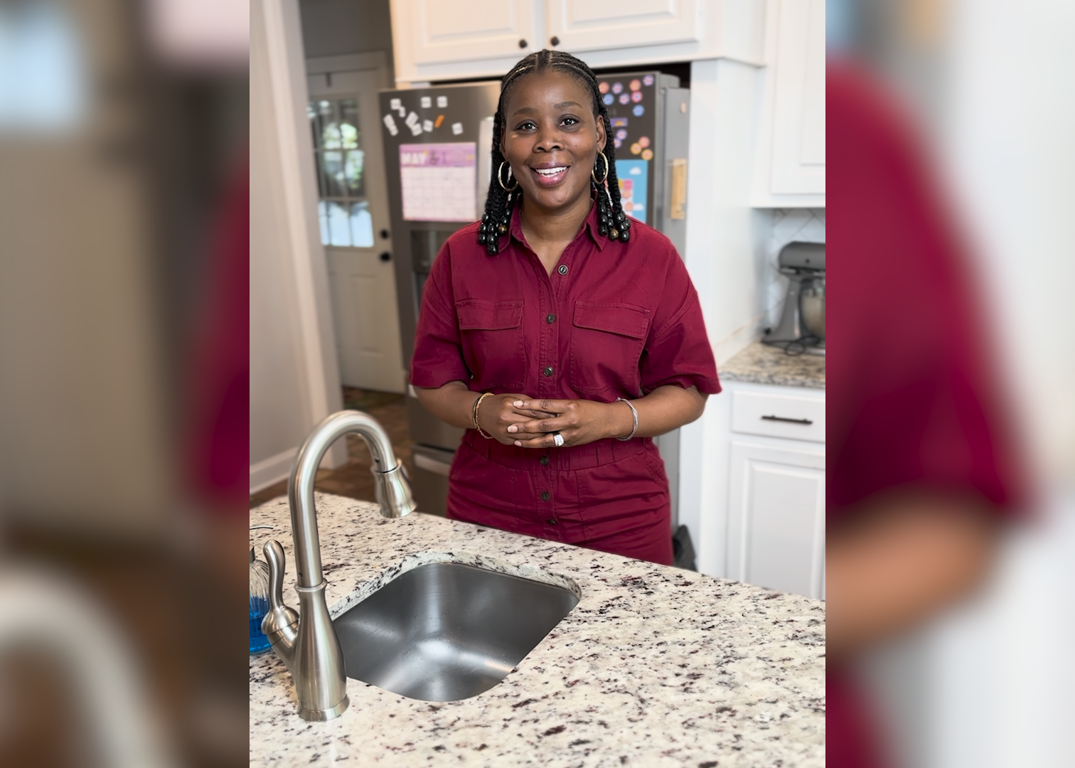 A woman stands at the kitchen sink.