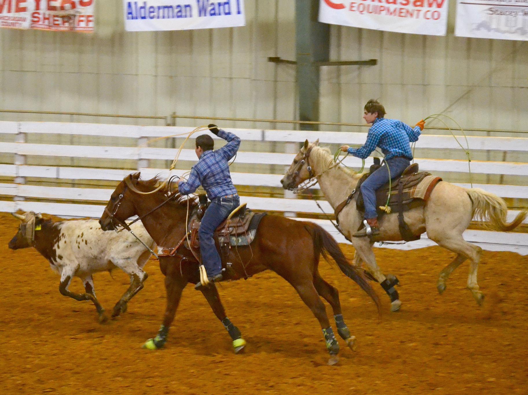 Jake Fulgham, the header, and Ty Edmondson, the heeler, take part in a team roping event at the 4-H Spring Rodeo Classic in April 2016 at the Chickasaw County Agri-Center.  (Photo by MSU Extension Service/Susan Fulgham)