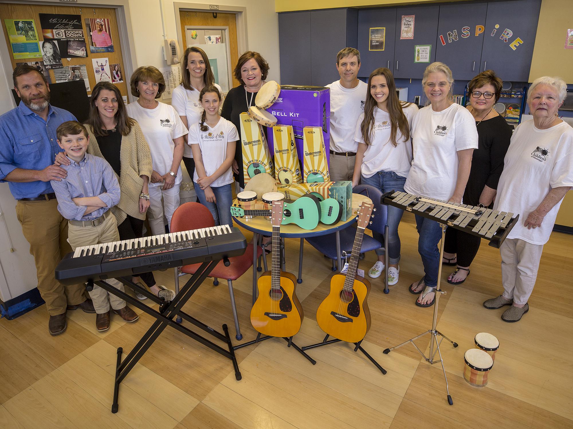 A group of people surround more than 20 musical instruments.