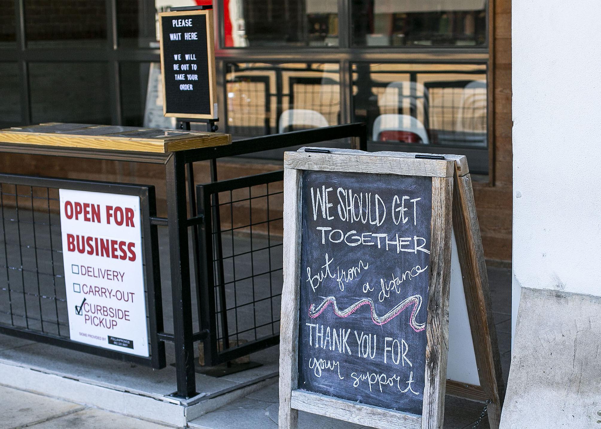 Signs with instructions for ordering curbside greet customers at a local coffee shop 