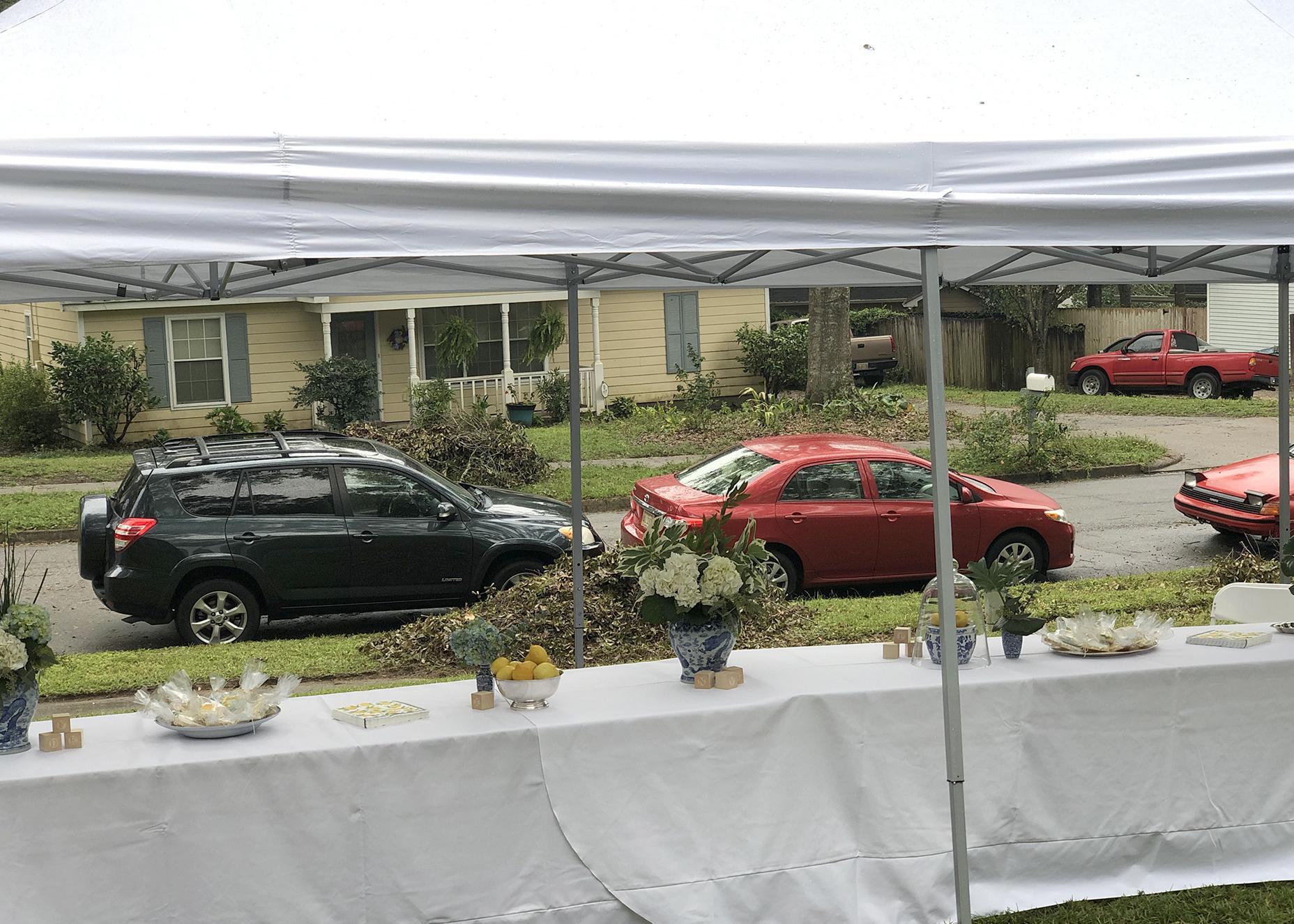 From inside a tent, cars can be seen lined up on the street.