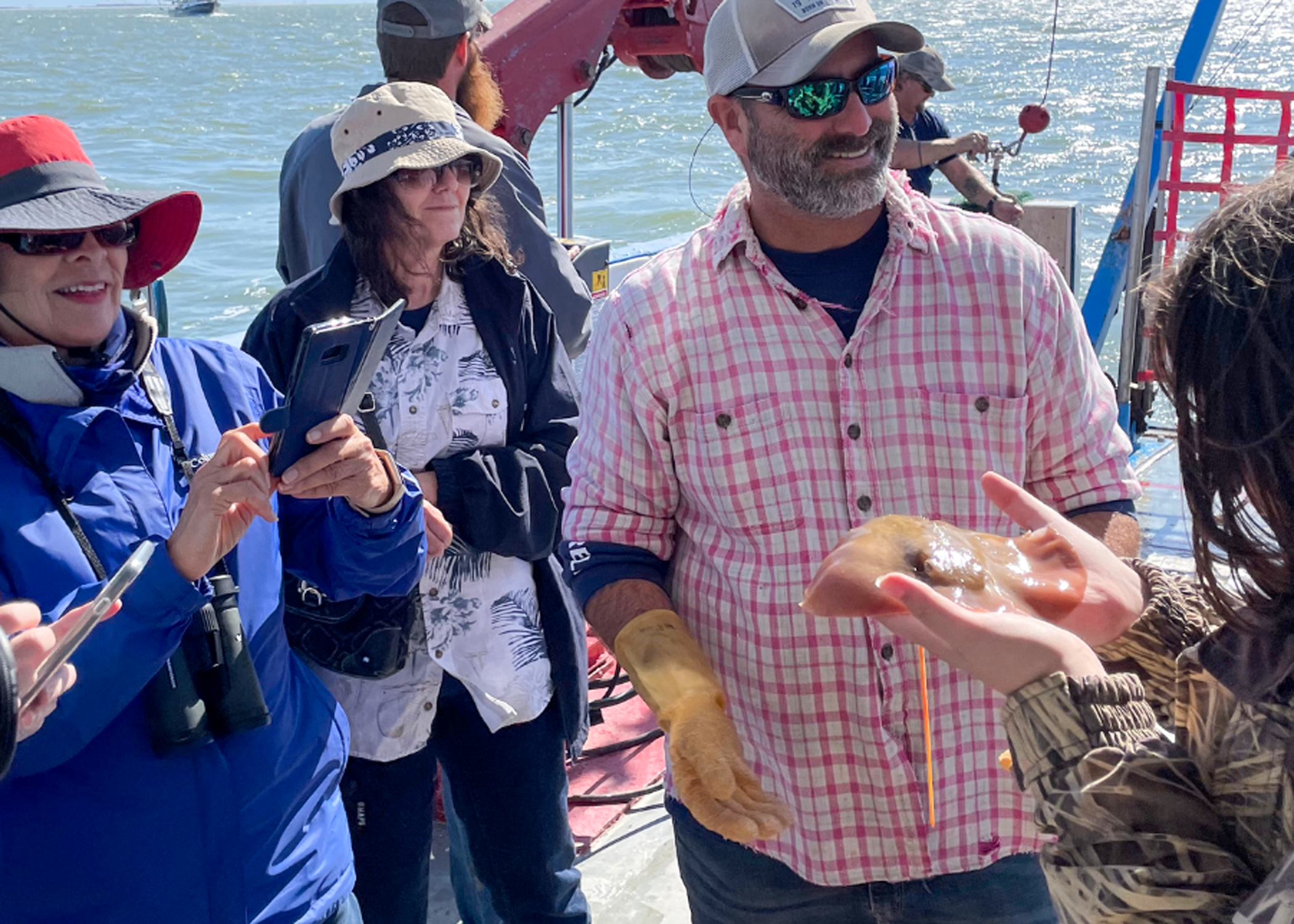 Man showing fish to group