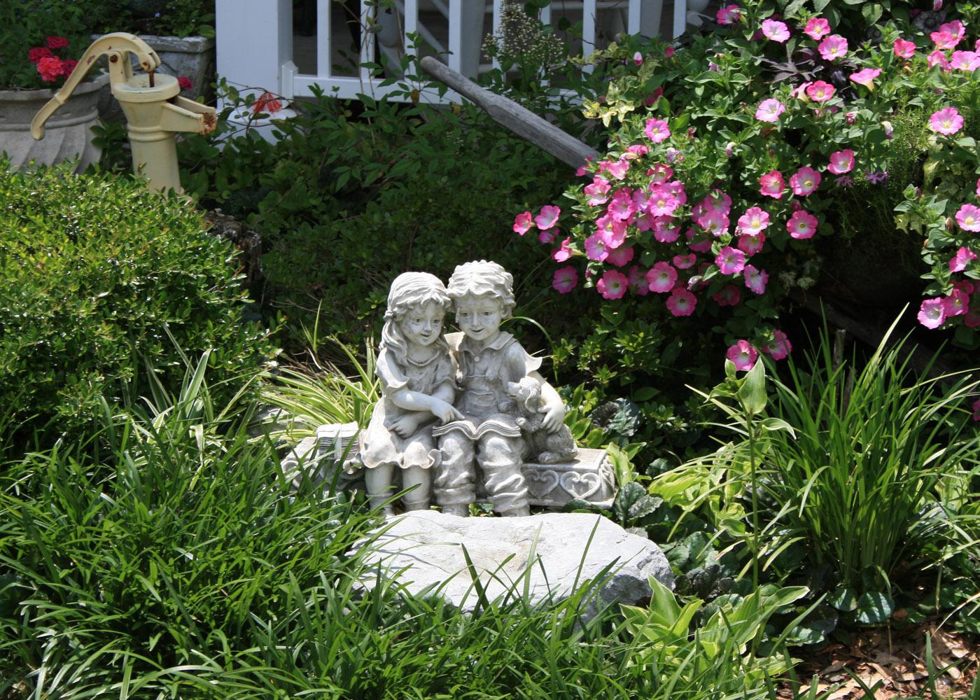 This sculpture  is surrounded by Giant Pink Supertunia and white variegated dianella behind and Big Blue Liriope.