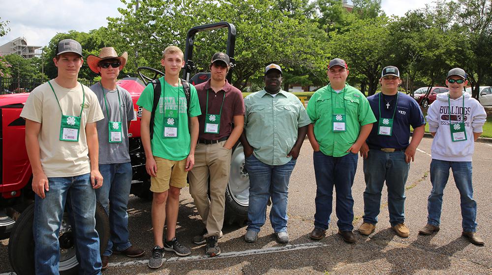 Young men in parking lot with tractor.