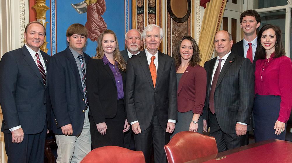 A group of individuals surround Senator Thad Cochran.