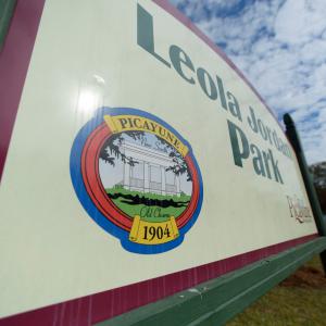 A white sign lists “Leola Jordan Park” in green lettering.