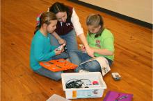 Kaitlyn Plance, left, and Jordan Jackson, right, work to build a robot with Amy Walsh, Amite County 4-H Agent. The youth are learning science, technology and engineering through the 4-H robotics program. (Photo by Mariah Smith)