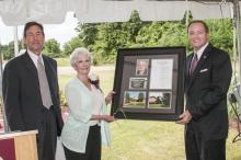 Vice President of the Division of Agriculture Forestry and Veterinary Medicine Greg Bohach, left, and Mississippi State University President Mark Keenum present Caroline Withers with a framed collage to commemorate the dedication of MSU's Frank T. (Butch) Withers Jr. Central Mississippi Research and Extension Center. A duplicate will hang inside the center. Withers and daughters Elizabeth Kilgore and Shelly Withers also received engraved cowbells as mementos of the occasion. (Photo by MSU Ag Communications/