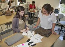 Ellen Sheppard, right, the lead apparel developer for REI, spent Oct. 2 and 3 at Mississippi State University working with Apparel, Textiles and Merchandising students on their design projects. Here, she gives feedback on fabric samples and drawings to Rachel Buchanan, a senior from Pontotoc. (Photo by MSU Ag Communications/Kat Lawrence)