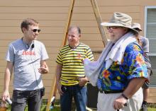 Heath Racela, "Ask This Old House" producer (left); homeowner Jesse Aguilar; and Gary Bachman, horticulture expert with Mississippi State University, share a laugh during a break while filming a segment for "Ask This Old House" Oct. 9 in Biloxi. Bachman provided off-camera assistance to the crew of the traveling home improvement show. The crew installed a backyard high tunnel to show Aguilar how to extend the gardening season. (Photo by MSU Ag Communications/Susan Collins-Smith)