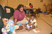 Miski Brown, a Mississippi State University Extension Service staff member with the Mississippi Child Care Resource and Referral Network, keeps Maylasia Haynes active while her family is in the American Red Cross Shelter at First Baptist Church in Louisville, Mississippi, on May 1, 2014.  (Photo by MSU Ag Communications/Linda Breazeale)