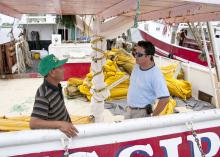 Phat Le, captain of the Mississippi III, discusses cleanup of the Deepwater Horizon oil spill with Extension Fisheries Technician Peter Nguyen. Many fishermen and shrimpers are working as oil spill cleanup contractors for BP. (Photo by Scott Corey)