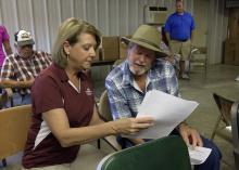 Two people sit down to look at a document together.