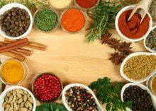 Closeup of herbs and spices on a cutting board.