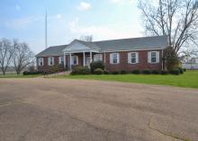 A brick building stands in front of an open field.