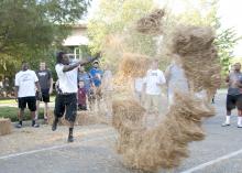 Mississippi State University defensive lineman Denico Autry of Albemarle, N.C., has explosive results with his throw during a friendly hay toss competition against fellow football players on the MSU campus Sunday afternoon, Aug. 19, 2012. The second annual Beefin’ up the Bulldogs included a steak supper and activities promoting MSU’s land-grant heritage. Sponsors included First South Farm Credit, Mississippi Cattlemen’s Association, Mississippi Beef Council and MSU’s Animal and Dairy Science Department. (Ph