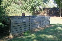 An enclosure can be a simple or elaborate way to keep a compost pile contained and working. This three-bin, wooden enclosure houses an active compost pile at MSU’s Truck Crops Branch Experiment Station. (Photos by Gary Bachman) 