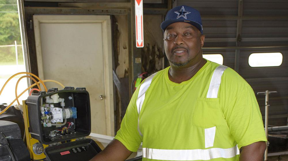 Steven Bell stands beside a truck housing a mosquito sprayer.