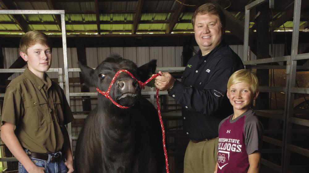 Joe Davis with two 4-H'ers with a champion heifer