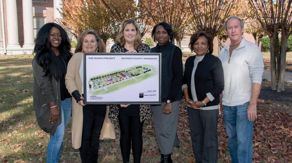 Members of The Marks Project in Quitman County hold a rendering of an improved community.