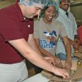 Mississippi State University food science club members, from left, Tony Garcia of Brandon, Gabrielle Bryant of Vicksburg and V. J. Radhakrishnan of India pack jars of muscadine jelly they made for area food pantries. (Photos by Patti Drapala)