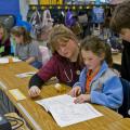 MSU veterinary student Shannon Vawter of Horn Lake works with third grade Starkville Academy students Carly Smith and Montana Brasher while MSU student Katie Ebers of Jackson (background) spends a moment with elementary student Mallory Barber. (Photo by Tom Thompson)