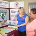 Mississippi State University Extension community health coordinator Ann Sansing reviews some of the Master Health Volunteer educational material with Annie Williams at the one-year anniversary celebration of the John Wesley Health Education Center in Durant, Mississippi, on July 25, 2014. (Photo by MSU Ag Communications/Linda Breazeale)