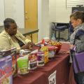 Mississippi State University Extension Service Child and Family Development agent Terri Thompson, left, gives Isabella Cornish a sample of an easy-to-make snack mix. The MSU Extension Service was one of several organizations participating in the Super Saturday healthy cooking event in Pascagoula, Mississippi on Nov. 15, 2014. (Photo by MSU Extension Service/Susan Collins-Smith)