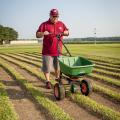 Barry Stewart, turf management specialist with the Mississippi Agricultural and Forestry Experiment Station, demonstrates fertilizing equipment on Aug. 29, 2013, on a recently cut patch of St. Augustine grass grown at Mississippi State University's R.R. Foil Research Center. (Photo by MSU Ag Communications/Scott Corey)