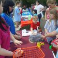 Volunteer teenagers use a prop resembling the human brain to demonstrate brain function to children.