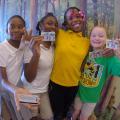 Four fourth-grade girls show off their personal identification cards that are passes to federal parks.