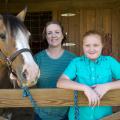 A young girl and her mother are pictured with their horse.