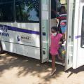 Two people step off a bus.